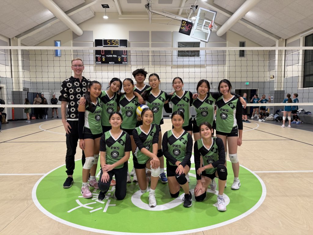 PKS volleyball team posing together in the gym