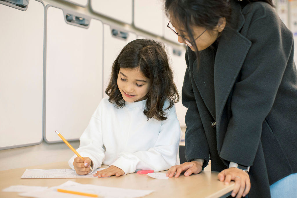 PKS student working one-on-one with a teacher during class